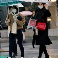Pedestres usam máscara de proteção em um bairro comercial de Tóquio.