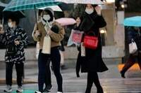 Pedestres usam máscara de proteção em um bairro comercial de Tóquio.