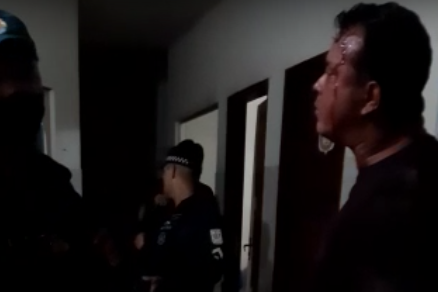 Vice-prefeito diz aos policiais que a farda não dá proteção nenhuma. Aparentemente, ele tem um ferimento na testa.