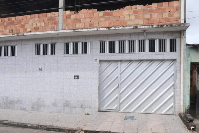 Na fachada do pavimento superior da casa, as marcas dos tijolos destruídos a socos