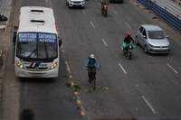 Ciclistas fazem malabarismos entre os veículos na rodovia