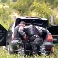 Imagens dos militares revistando o carro usado na fuga dos executores do sargento da Polícia Militar.