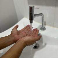 A imagem duas mãos aparando água de uma torneira