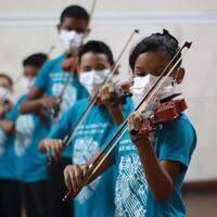 Crianças iniciam os estudos com canto coral e flauta doce para depois aprender novos instrumentos, como o violino.