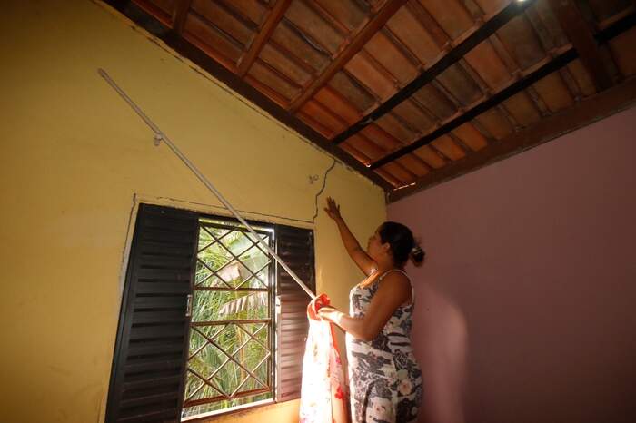 Danierika Barbosa mostra rachaduras na casa onde mora, que seriam provocadas por explosões em mina