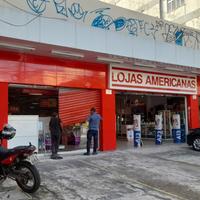 Funcionários consertam porta das lojas Americanas que foi arrombada nesta terça-feira