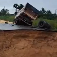 Um caminhão carregado quase não consegue passar e acabou tombando logo após a pista se romper