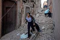 Uma mulher evacua com seus pertences em meio aos escombros na cidade velha de Marraquexe, danificada pelo terremoto, em 9 de setembro de 2023.