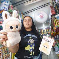 Vendedora mostra boneco Labubu - uma das tendências de vendas no comércio popular de Belém.