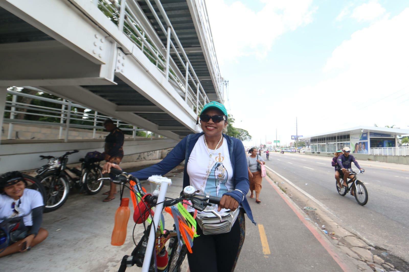 A auxiliar de escritório Luiza Oliveira, 46, aguarda pela passagem da berlinda enquanto descansa, após ter percorrido parte do trajeto de bicicleta