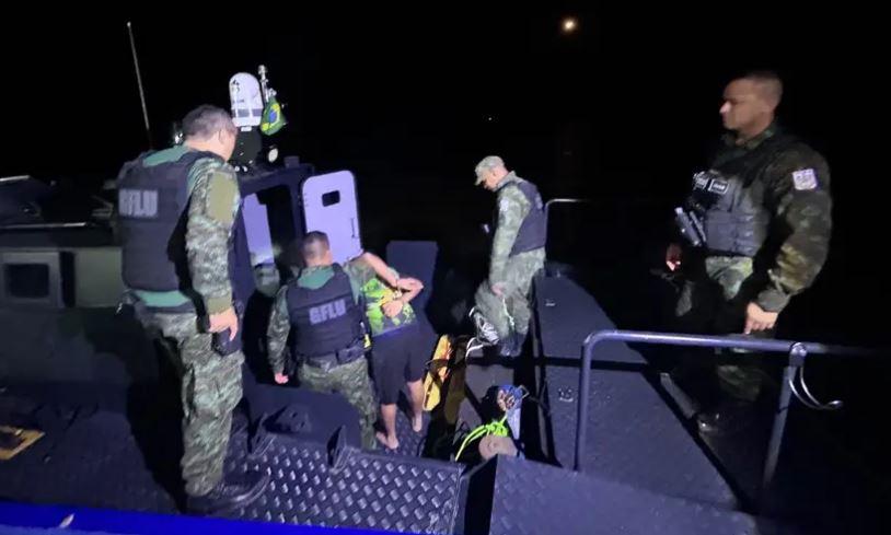 A imagem em destaque mostra agentes da Base Fluvial Integrada “Candiru” com o suspeito detido após a localização das drogas.