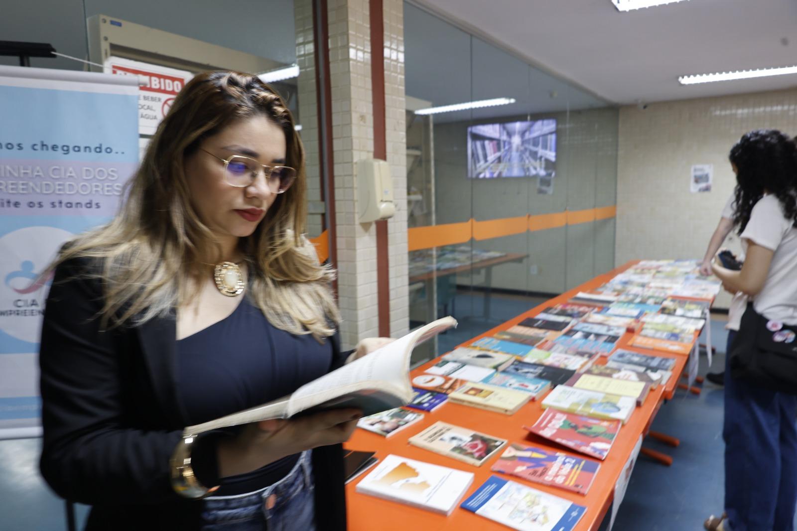 A imagem em destaque mostra a diretora da Biblioteca Central e coordenadora do sistema de bibliotecas da Universidade, Michelly Nascimento.
