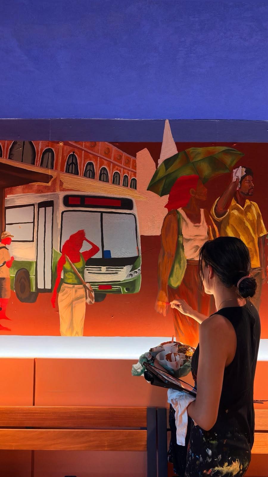 Mama Quilla durante o processo de pintura de sua obra no Espaço Quente