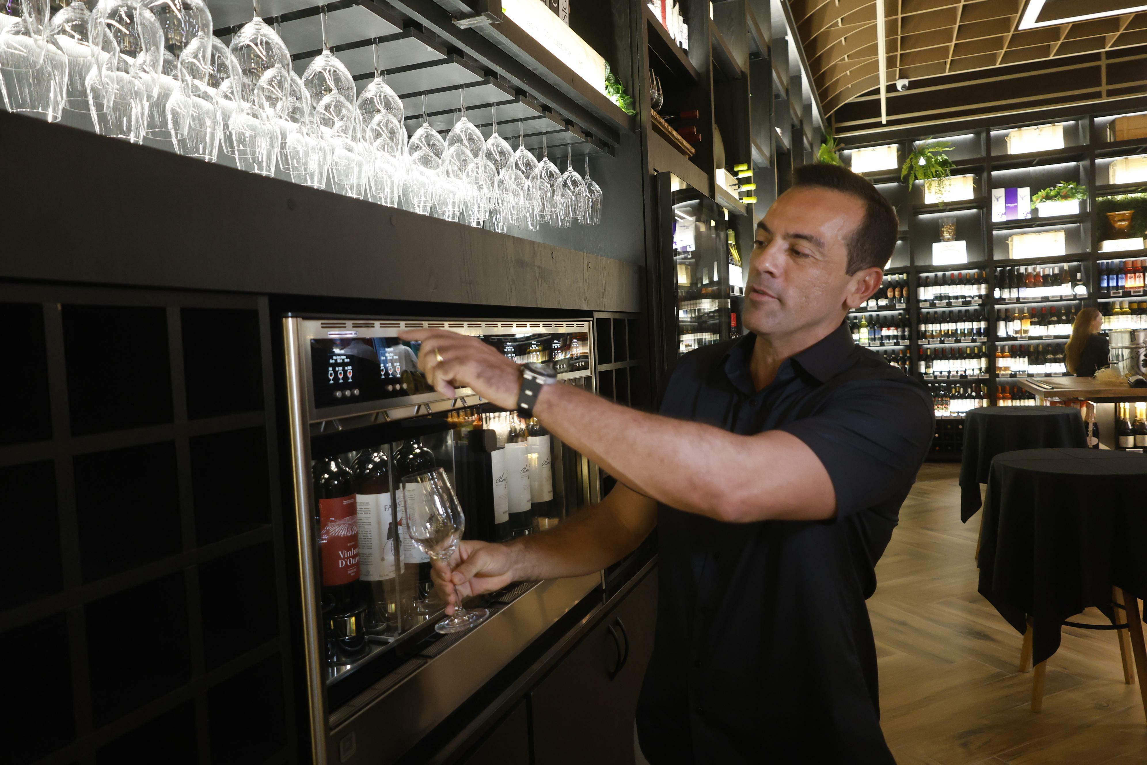 O diretor comercial do +B, Alex Mascarenhas, apresenta a máquina de degustação de vinhos nacionais e internacionais na adega da nova loja